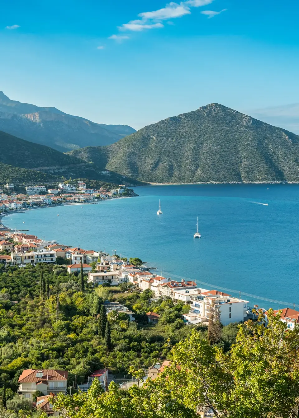 Coastal town of Tyros beside a blue bay and green mountains